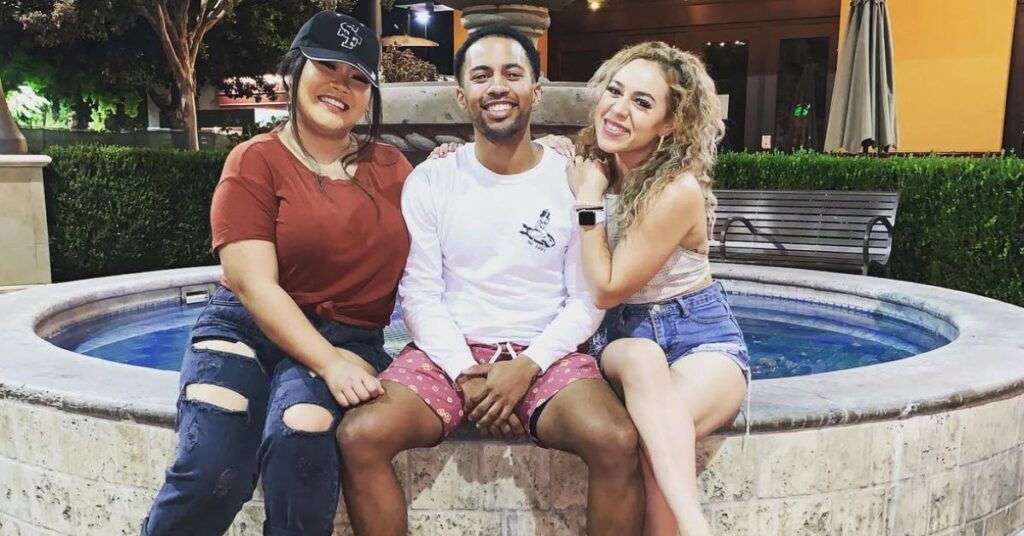 three friends posing on a water fountain together