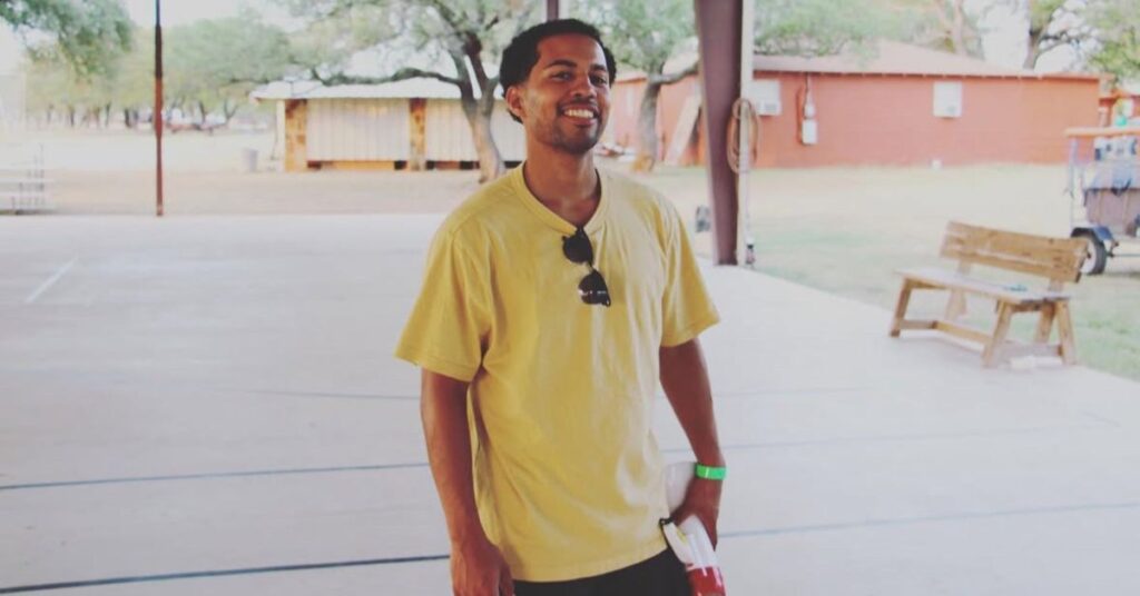 summer church camp 2022 recreational director in yellow shirt with ray bands hanging on shirt