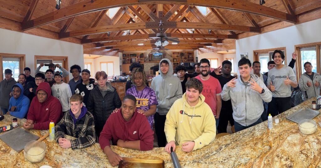 group of high school student boys in the kitchen getting ready for dinner