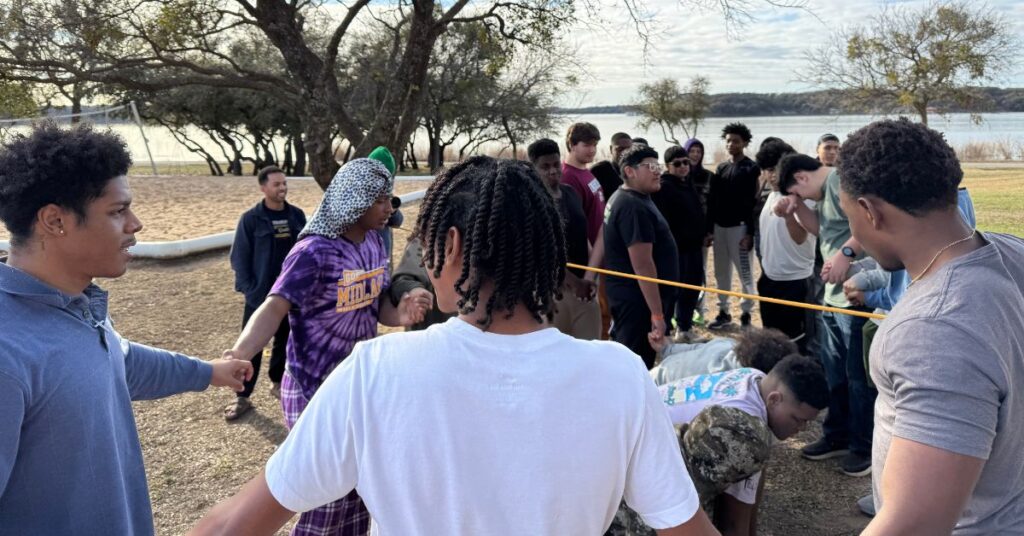 group of high school students at church retreat performing a group challenge