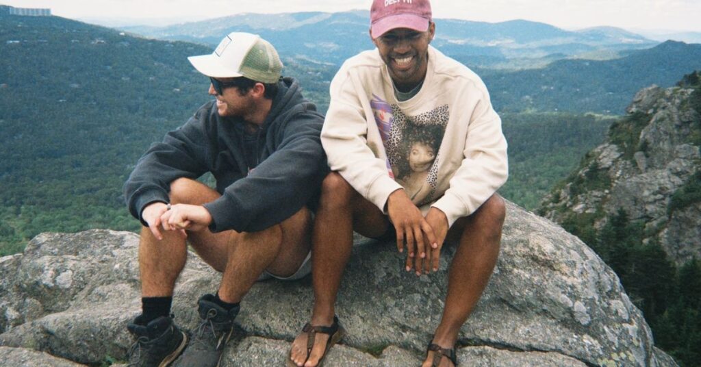 two friends smiling and laughing on top of a mountain in North Carolina
