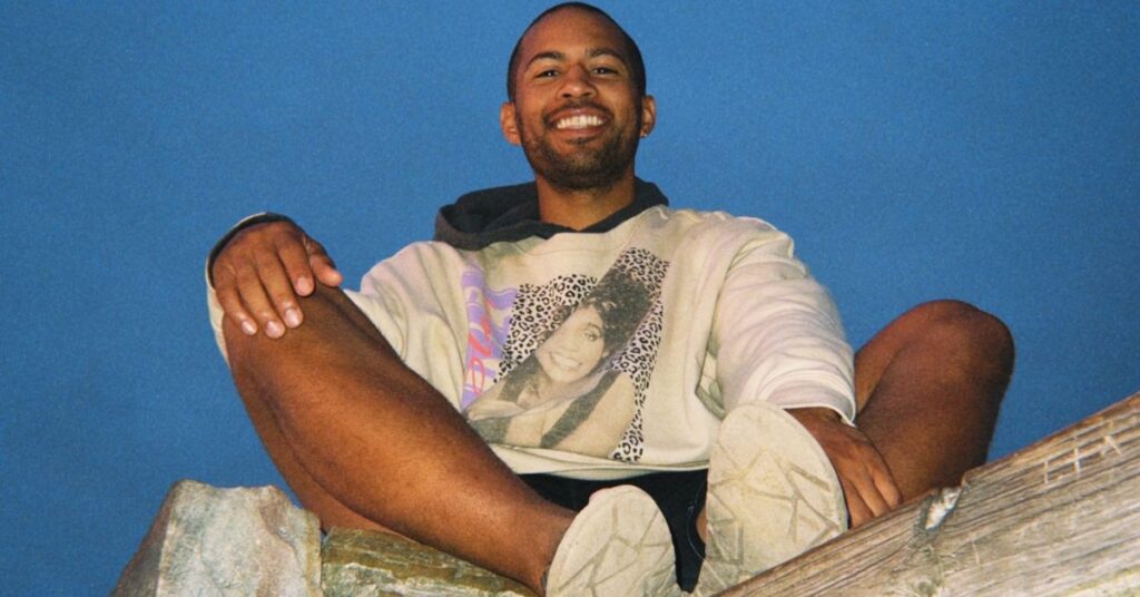 smiling and looking down atop a mountain