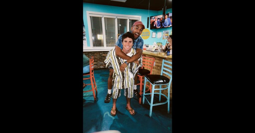 two friends in quirky thrift clothes one on the others back