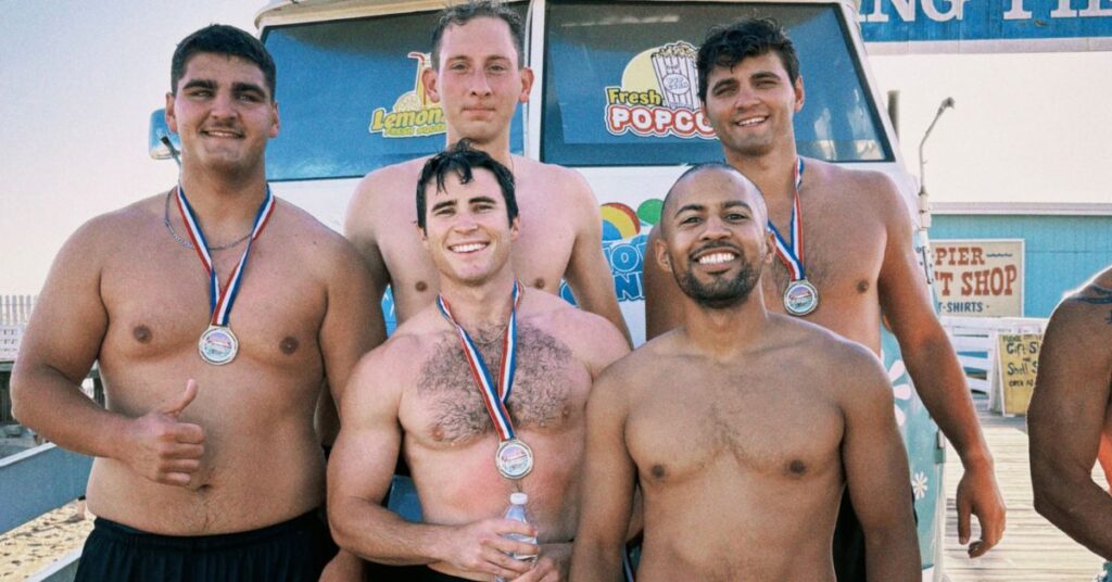 5 guys wearing their medals after finishing a beach triathlon